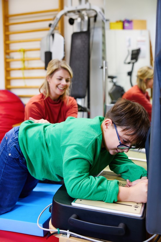 Junge stützt sich auf Galileo-Trainingsgerät